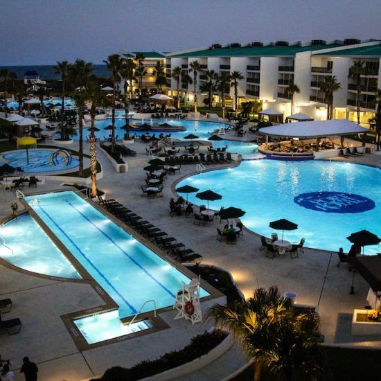 an aerial view of a resort pool at night