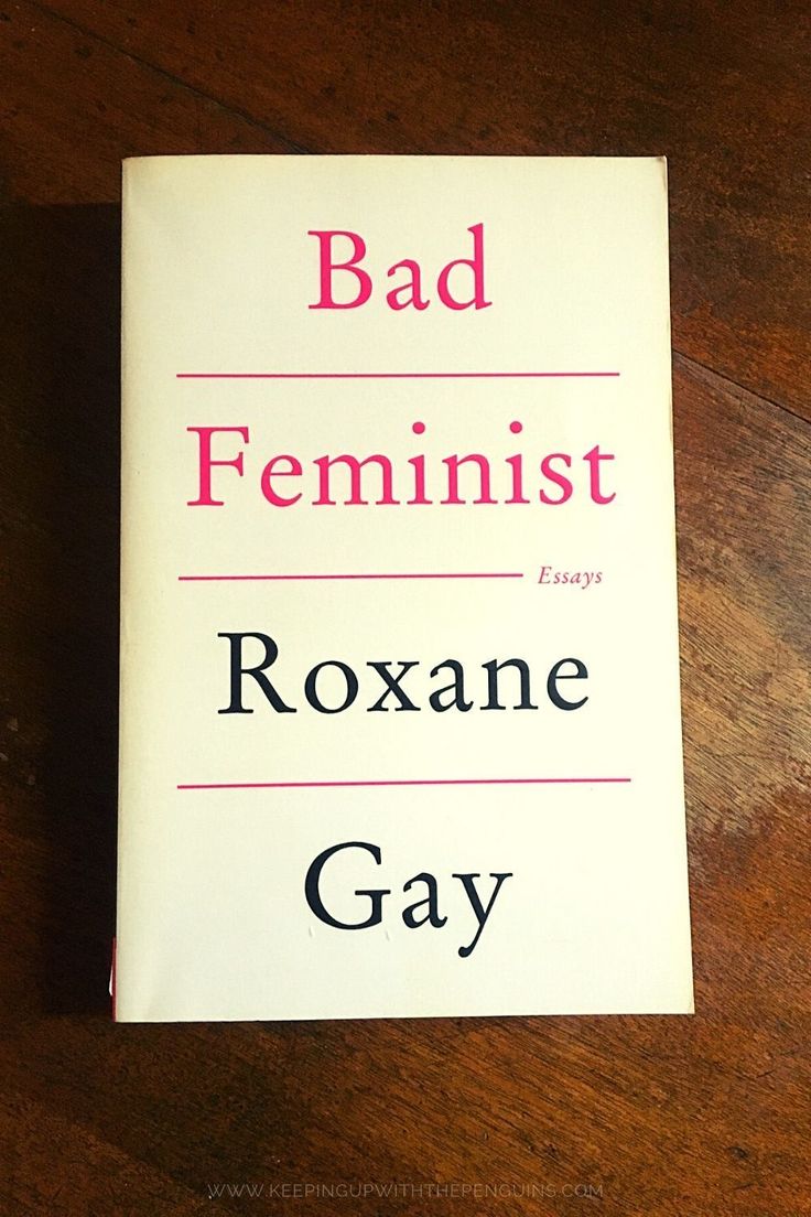 the book bad feminist by roxane gay is on a wooden table with pink lettering