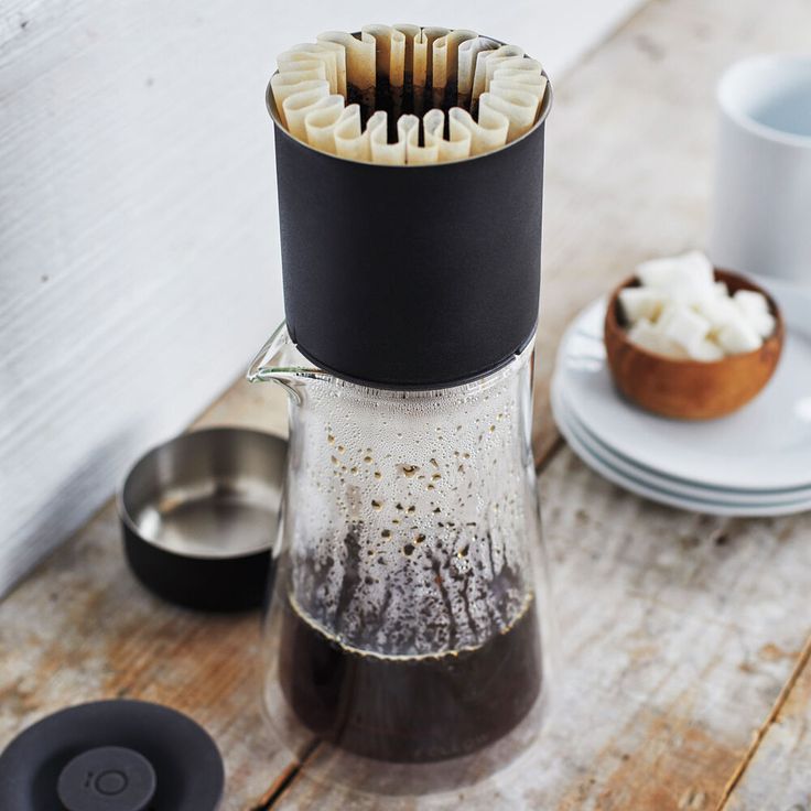 a coffee pot filled with marshmallows on top of a wooden table