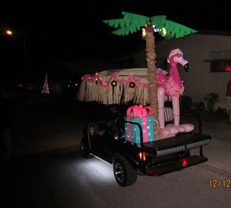 a decorated horse on the back of a pick up truck in front of a palm tree