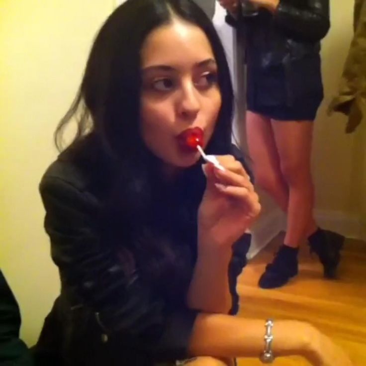 a woman sitting on the floor brushing her teeth