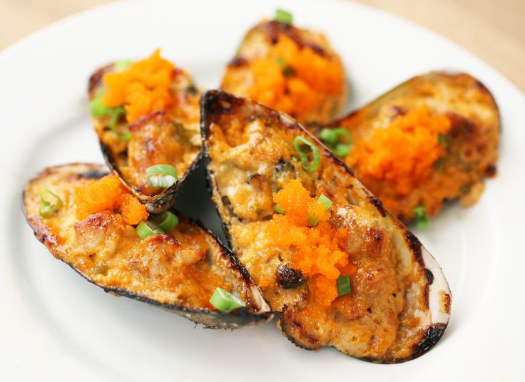 cooked eggplant and carrots on a white plate with green garnish