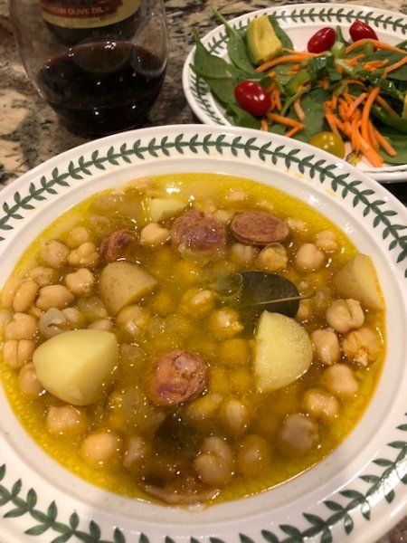 two bowls of soup with vegetables and meat on the side