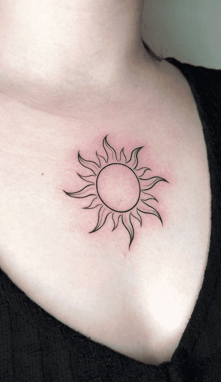 a woman's chest with a small sun tattoo on her left shoulder and right breast