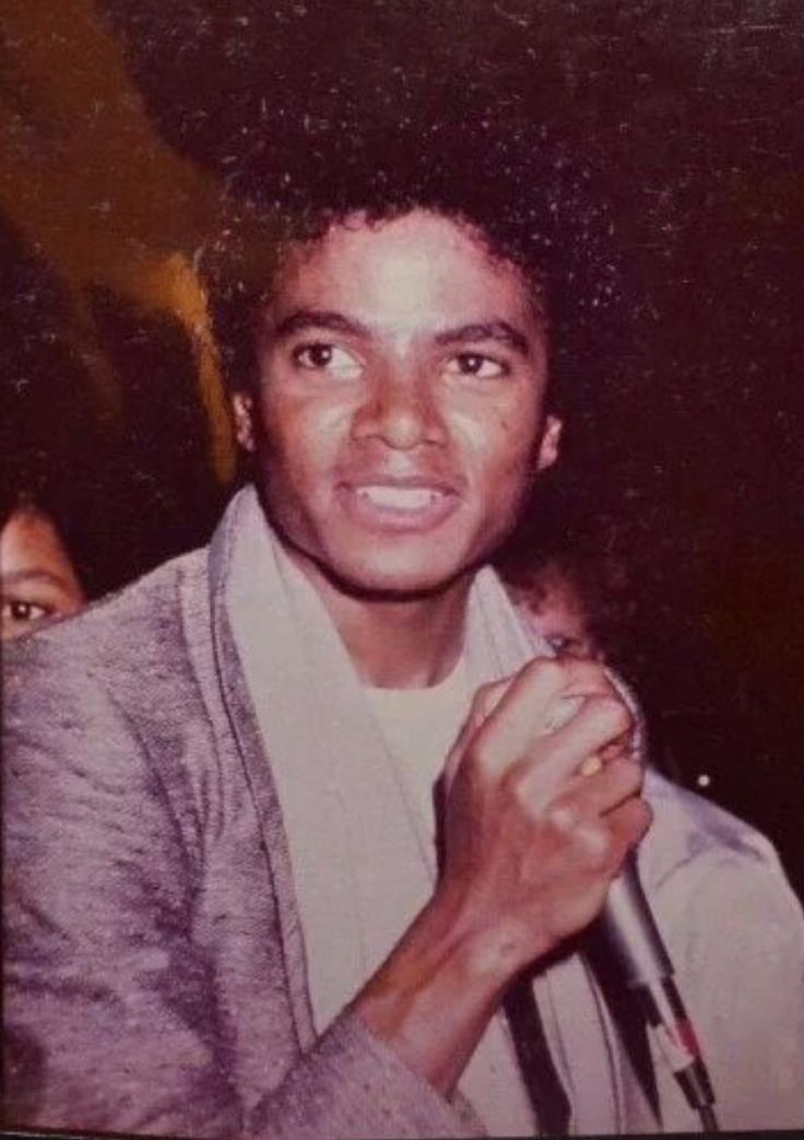 an old photo of a young man holding a microphone