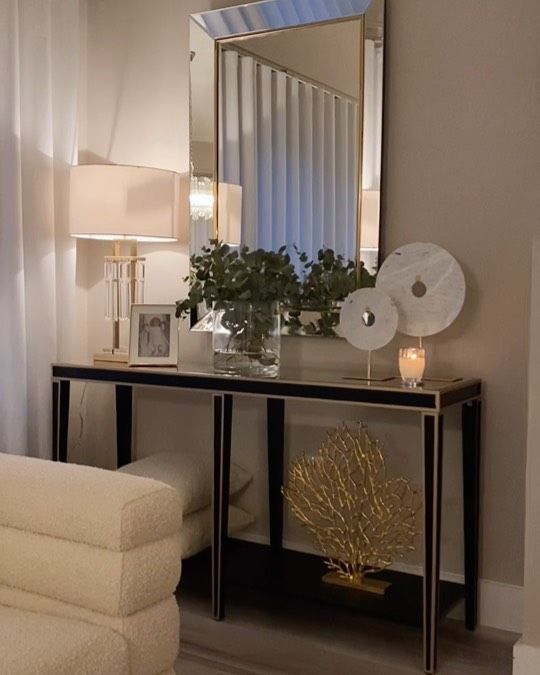 a white couch sitting next to a table with a mirror on top of it