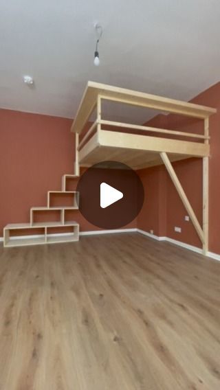 an empty room with stairs and a loft bed in the center, on top of a wooden floor