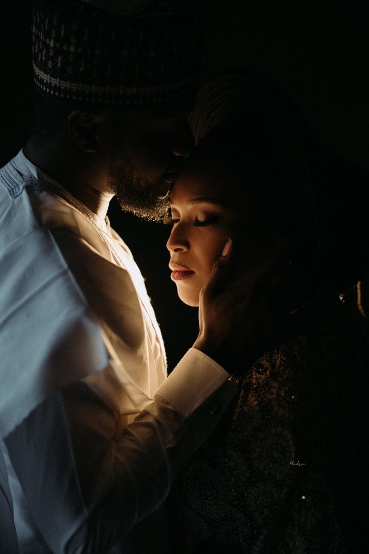 a man and woman standing next to each other in the dark