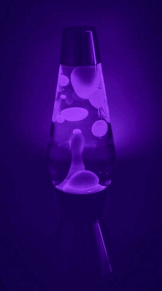 a purple light is shining on a glass vase with liquid in it and bubbles coming out of the top