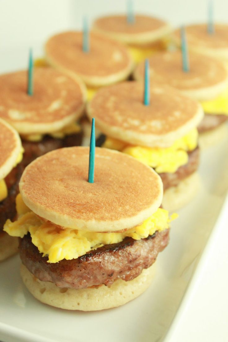 pancakes with eggs and sausage are arranged on a plate