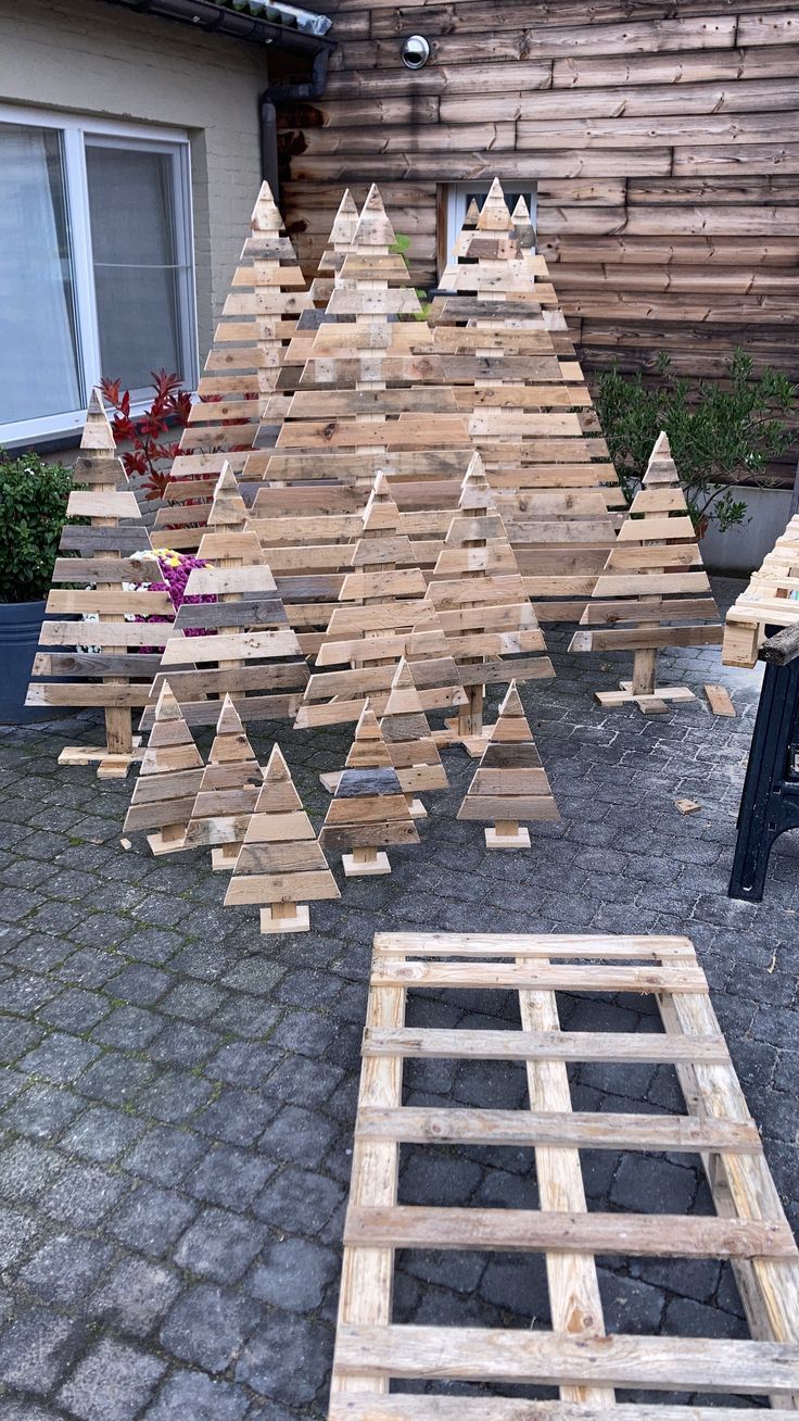 several wooden christmas trees sitting on top of a patio