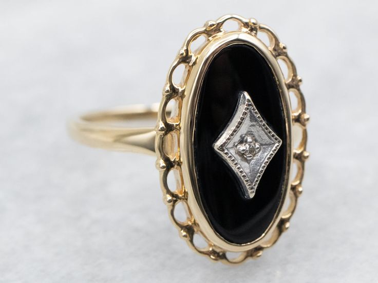 This vintage ladies' ring is a jewelry piece that's become an icon of the Mid-1900s! Popular and versatile, this ring features a pure black onyx stone that gives it a sophisticated style. At the center of the onyx is mounted a sparkling diamond, itself set in a radiant placard of white gold. Metal: 10K Yellow and White GoldGem: Black OnyxGem Measurements: 7.3 x 15.1 mm, OvalAccent: Diamond .01 Carats, SI1 in Clarity, I in ColorRing Size: 7Marks: "10K (P)" Stamped on the inside band Vintage Onyx Wedding Ring, Onyx Rings, Cameo Ring, Ladies Ring, Black Onyx Stone, Pure Black, Sparkling Diamond, Black Onyx Ring, Art Deco Engagement Ring