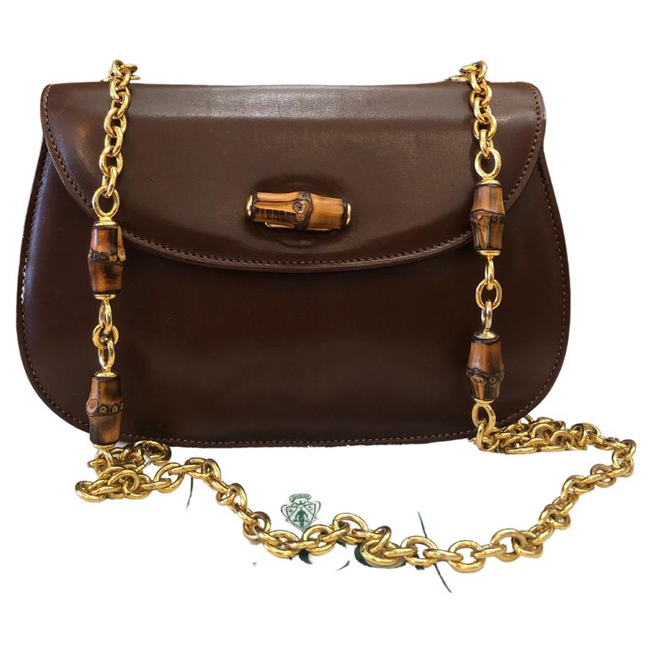 This vintage GUCCI bamboo chain shoulder bag is crafted of smooth calfskin leather in brown featuring a sturdy gold toned chain with bamboo internodes. Front flap bamboo turnlock closure opens to a new beige interior featuring a zippered pocket. Made in Italy. Measures approximately 8.75 x 6 x 3 inches Chain drop 18 inches. Comes with dustbag. Condition: Generally in good vintage condition with minor signs of wear Outside: Minor scratches on leather exterior Inside: Interior fully re-lined and f Gucci Chain Bag, Gucci Vintage Bag, Structured Shoulder, Beige Interior, Chanel Flap Bag, Gucci Outfits, Gucci Bamboo, Gucci Shoulder Bag, Purple Bags