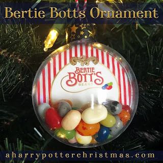 a glass ornament filled with jelly beans on top of a christmas tree branch