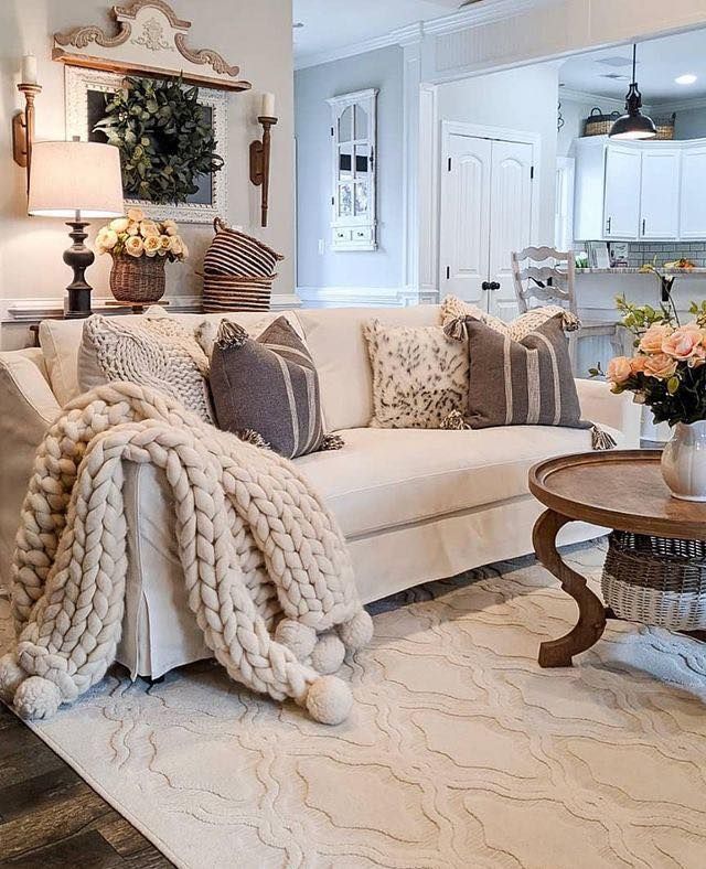 a living room filled with lots of furniture and flowers on top of a coffee table