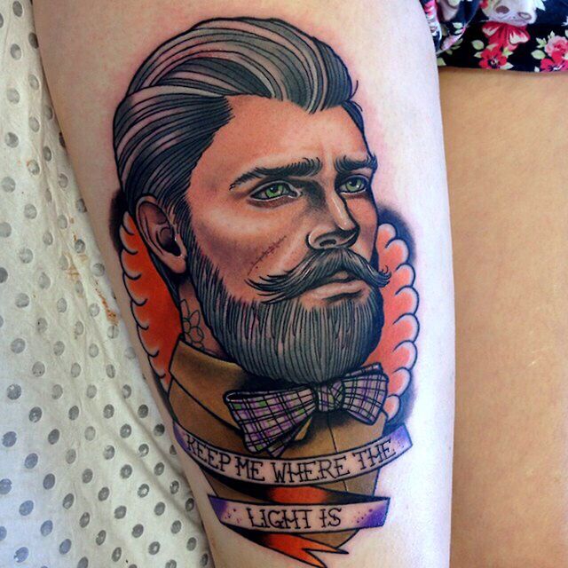 a man with a beard and bow tie tattoo on his arm, next to a woman's thigh