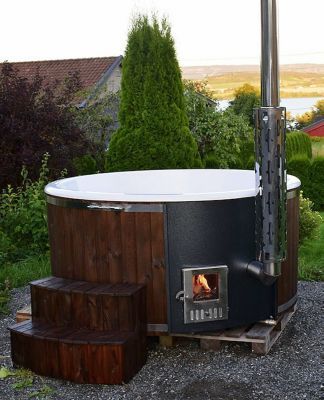 an outdoor hot tub sitting on top of a gravel field