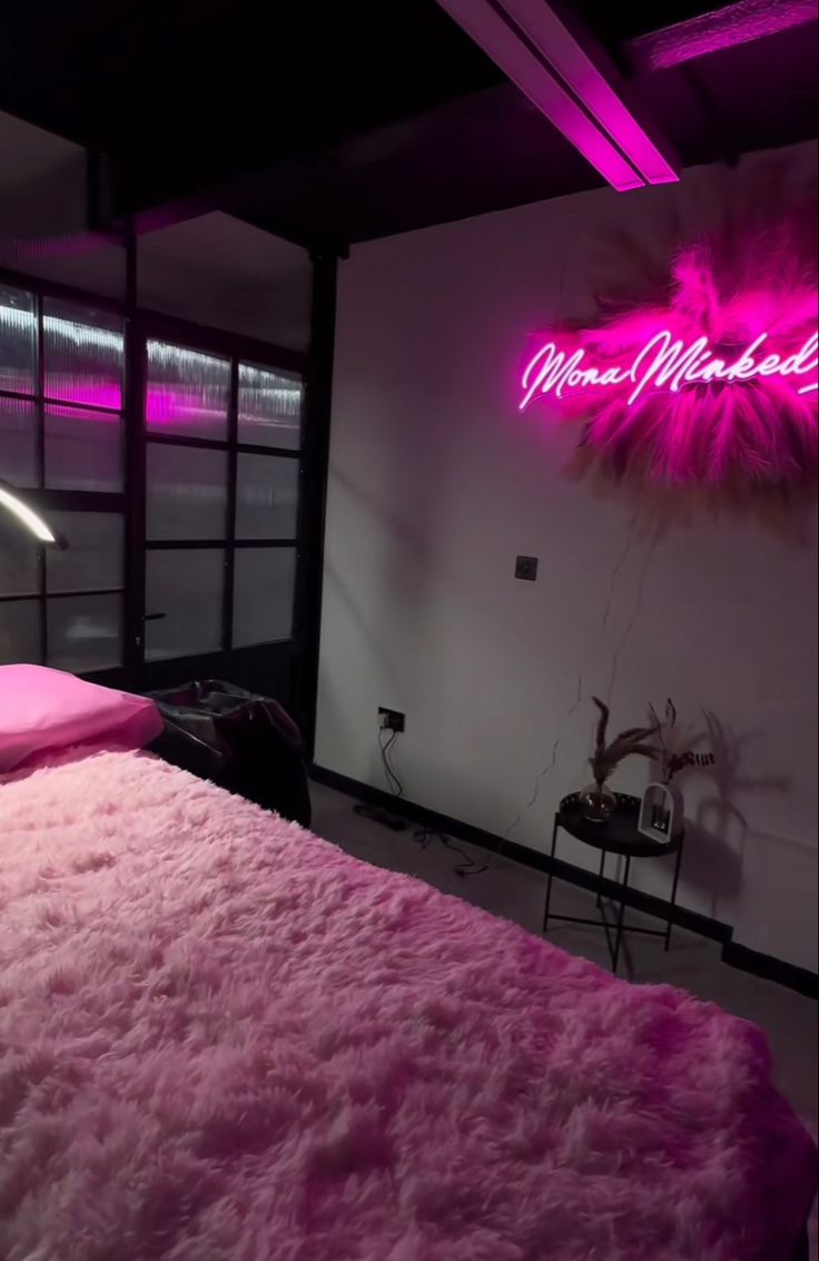 a pink bed in a dark room with neon lights