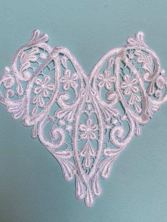 an intricately designed piece of white lace on a blue background with the word love written across it