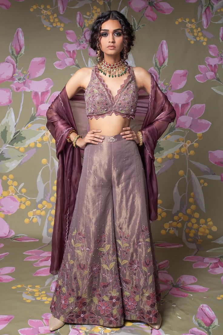 Wine palazzo with hand embroidered floral motifs. Paired with embroidered blouse and glass silk scalloped hem dupatta.
Components:3
Pattern:Embroidered
Type of Work:Floral Motifs
Neckline:V-Neck
Sleeve Length:Sleeveless
Fabric:Blouse and Palazzo: Kota Silk; Dupatta: Glass Silk
Color:Purple
Other Details:
Cutwork blouse hem
Scalloped hem dupatta
Occasion:Destination Wedding - Aza Fashions Blouse And Palazzo, Cutwork Blouse, Silk Orchids, Palazzo Set, Hem Blouse, Purple Blouse, Silk Dupatta, India Fashion, Scalloped Hem