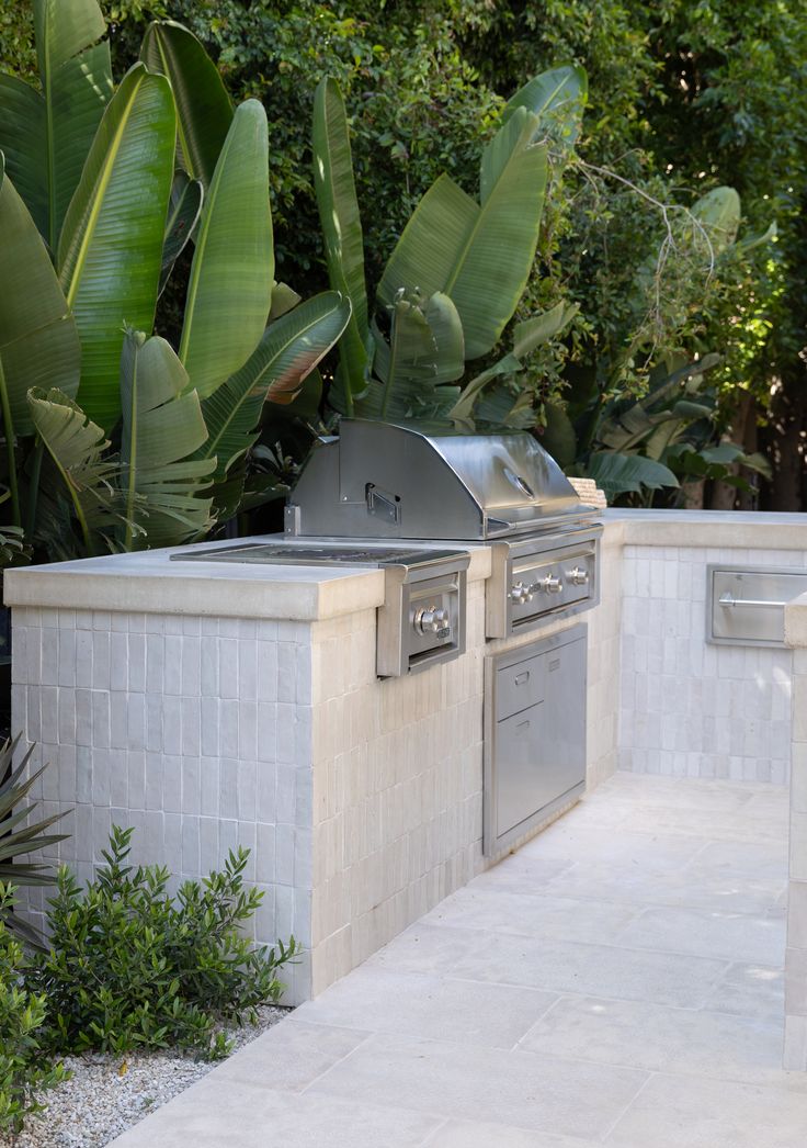 an outdoor kitchen with grill and seating area