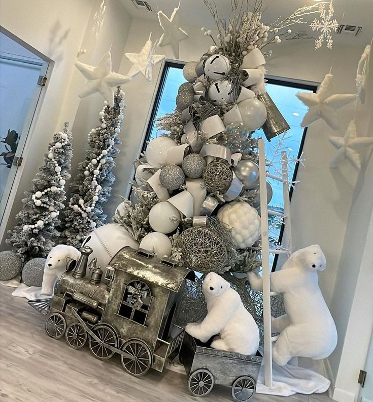 a christmas tree decorated with white and silver balls, snowflakes and polar bears