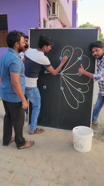 three men standing around a chalk board drawing something on it