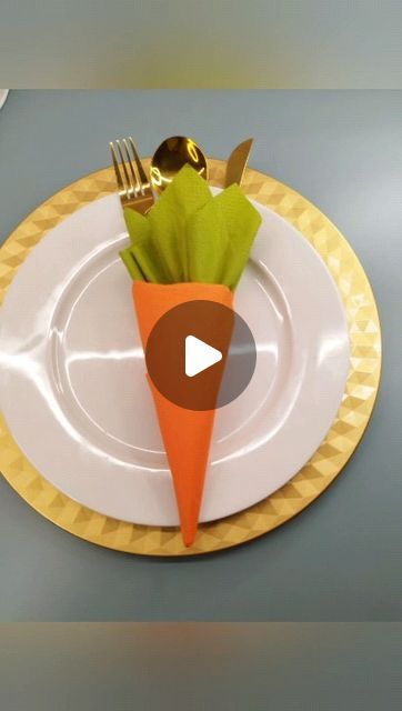 a plate with a carrot on it and fork, knife and spoon in the middle