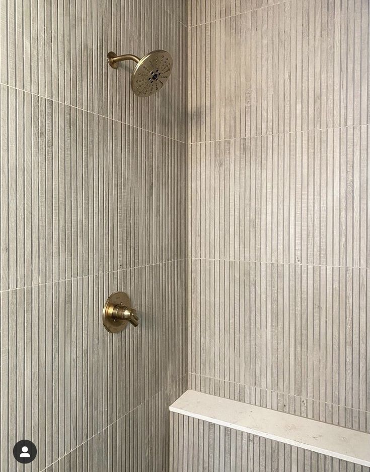 the shower head and hand shower faucet are shown in this bathroom with beige tile