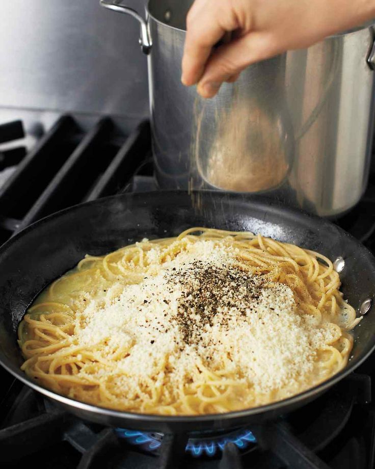 someone is cooking pasta in a pan on the stove