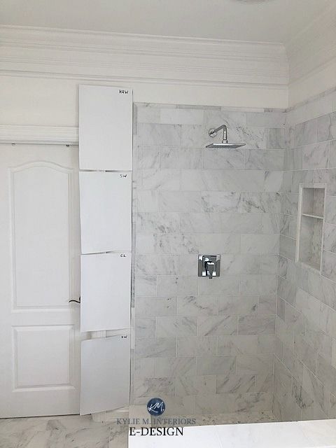 a white bathroom with marble walls and floor