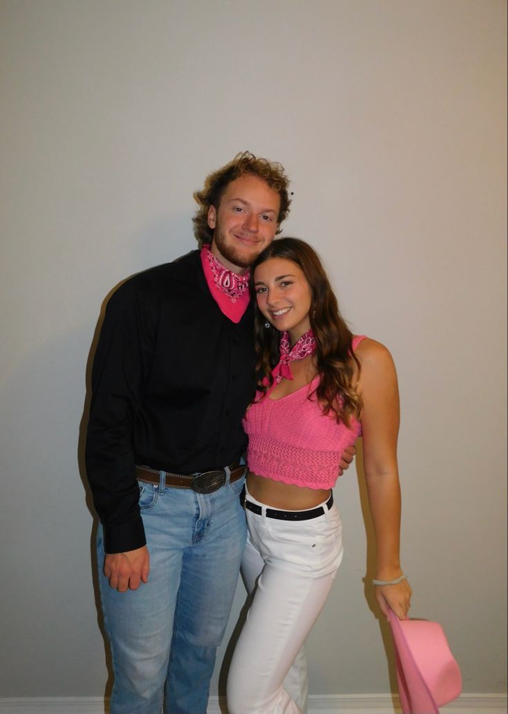 the man and woman are posing for a photo in front of a wall with a pink cowgirl bandana