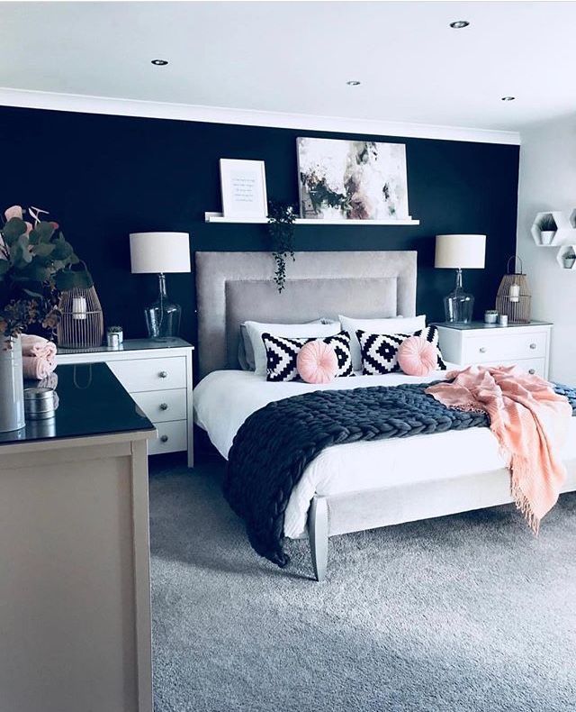 a black and white bedroom with pink accents