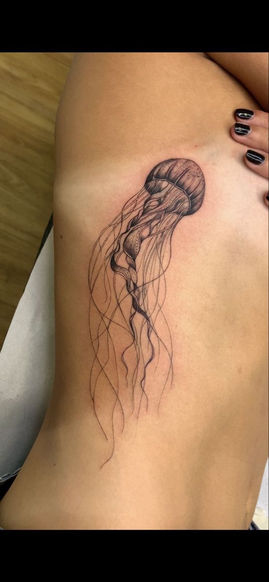 a woman's stomach with a tattoo of a jellyfish