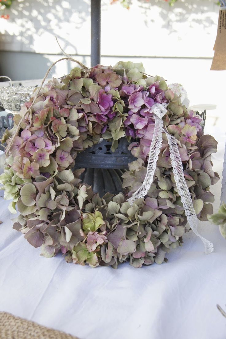 a wreath with purple flowers is sitting on a table