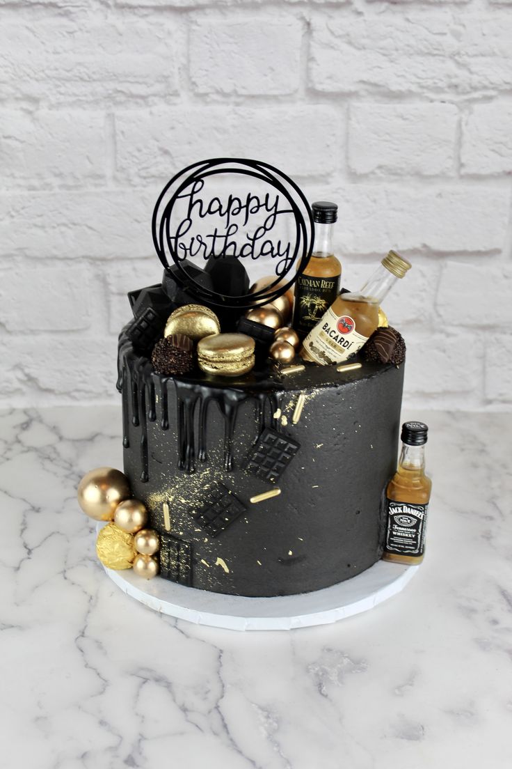 a black and gold birthday cake with happy birthday sign in the middle, surrounded by confetti