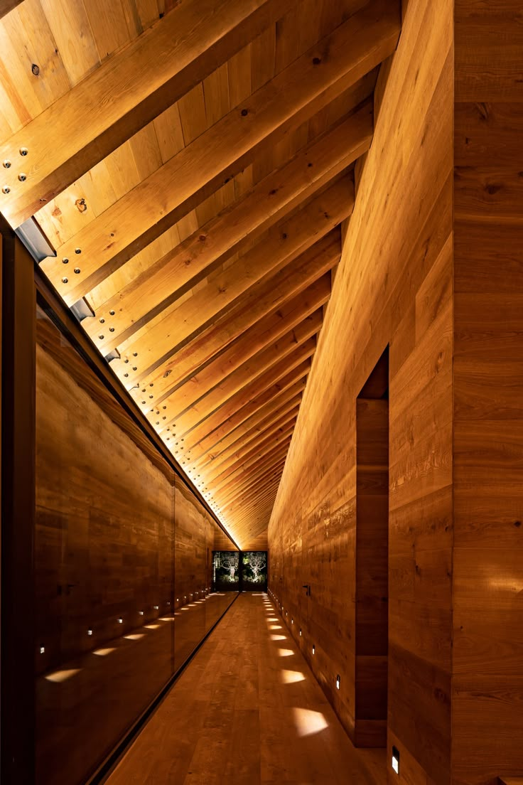 an empty hallway with wooden walls and ceiling