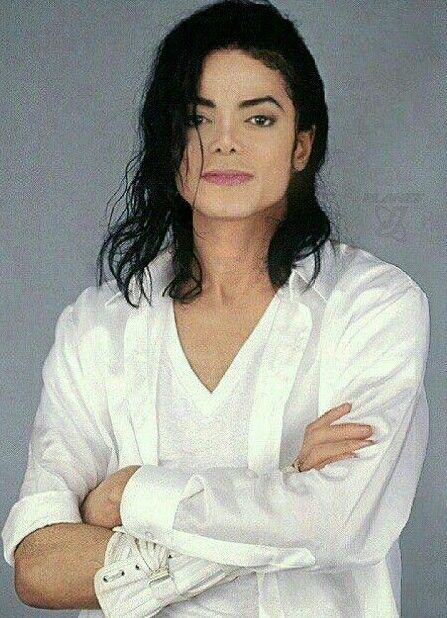 michael jackson is standing with his arms crossed