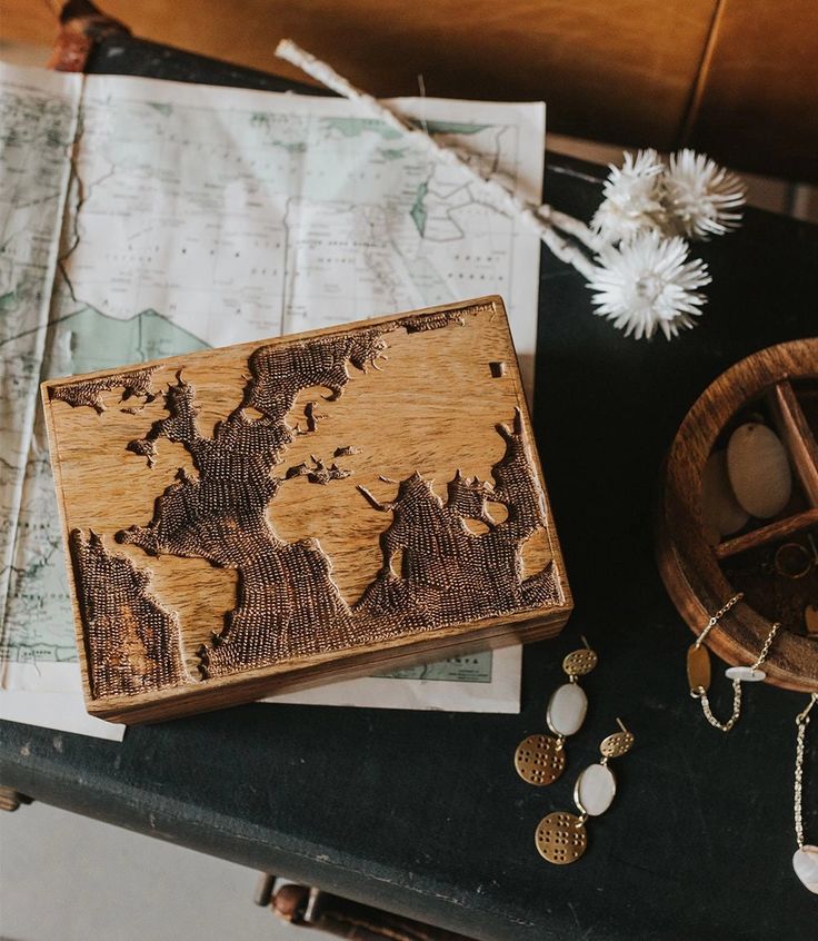 a wooden box sitting on top of a table next to a map and other items