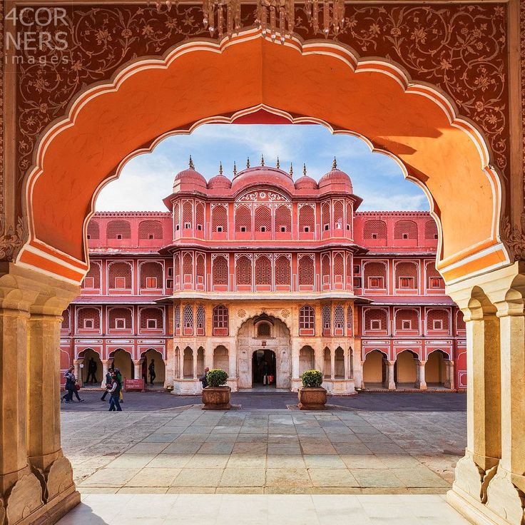 an archway leading to a pink building with arches