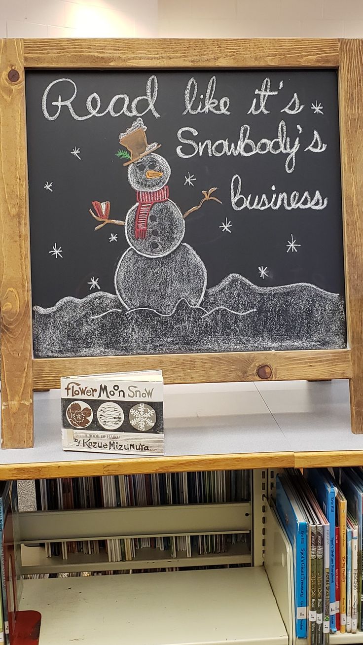 there is a chalkboard with a snowman on it in the library and bookshelves