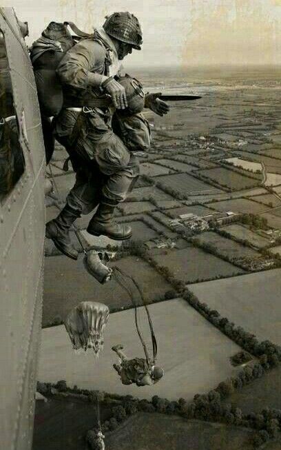 a man in uniform is hanging off the side of an airplane