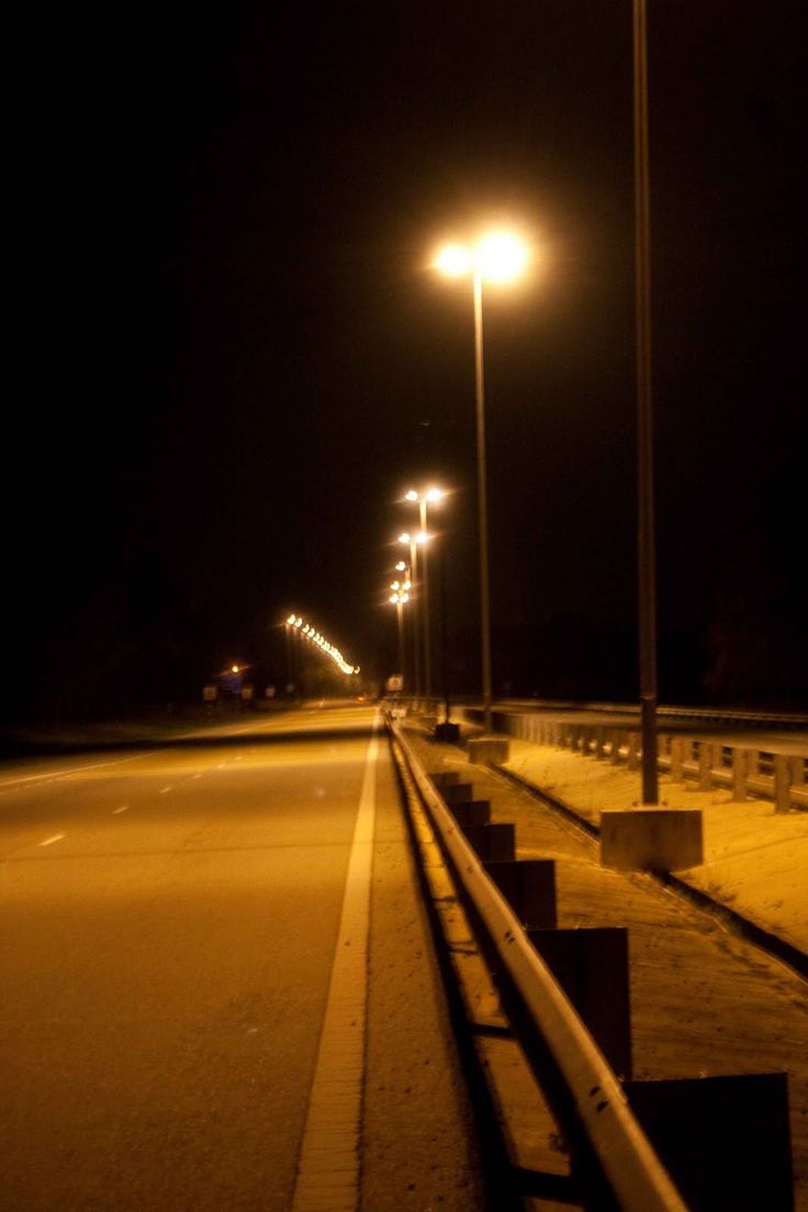 an empty road at night with street lights