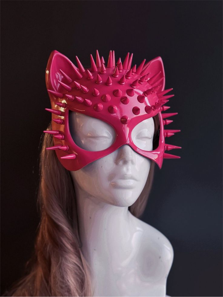 Step into the world of sleek enigma with our sexy cat mask inspired by Cat Woman. This mask will give your look a touch of seductive charm and edgy allure. The spikes add a hint of danger and edginess, reflecting the fierce and enigmatic nature of the feline spirit. Glide through cosplay events or Halloween costume parties as a seductive figure, leaving a trail of admiration in your wake. Age Group/Gender - Adult/Women Size/Type - One size fits all adults Mask Color - Pink Mask Material - Polyre Fantasy Cat Ears Costume Accessories For Party, Halloween Masquerade Mask With Cat Ears, Punk Cat Ears Costume Accessories For Party, Punk Style Cat Ear Party Accessories, Novelty Eye Mask For Party, Novelty Eye Mask For Parties, Punk Style Cat Ears Costume Accessories For Party, Punk Style Party Mask Costume Accessories, Novelty Cat Design Costume Accessories For Party