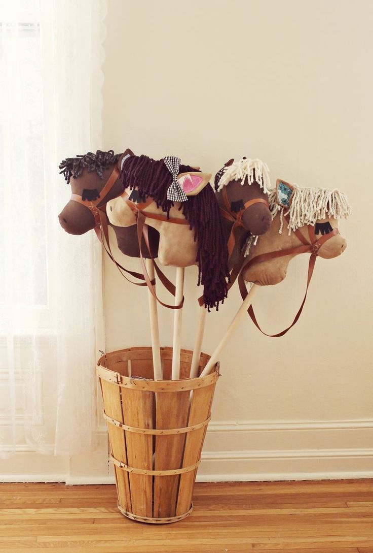 a bucket filled with lots of hats on top of a hard wood floor next to a window