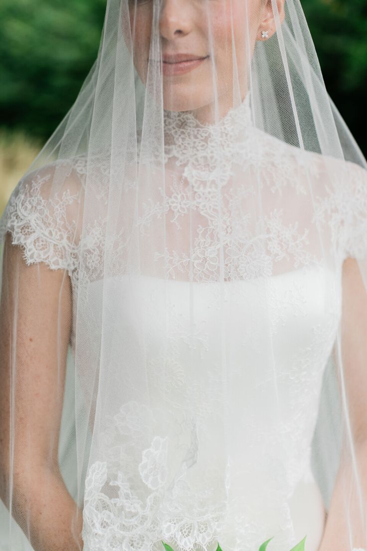 a woman wearing a wedding veil and holding a bouquet