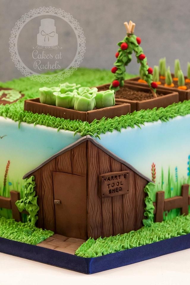 a cake that is shaped like a farm house with trees and grass around it on a table