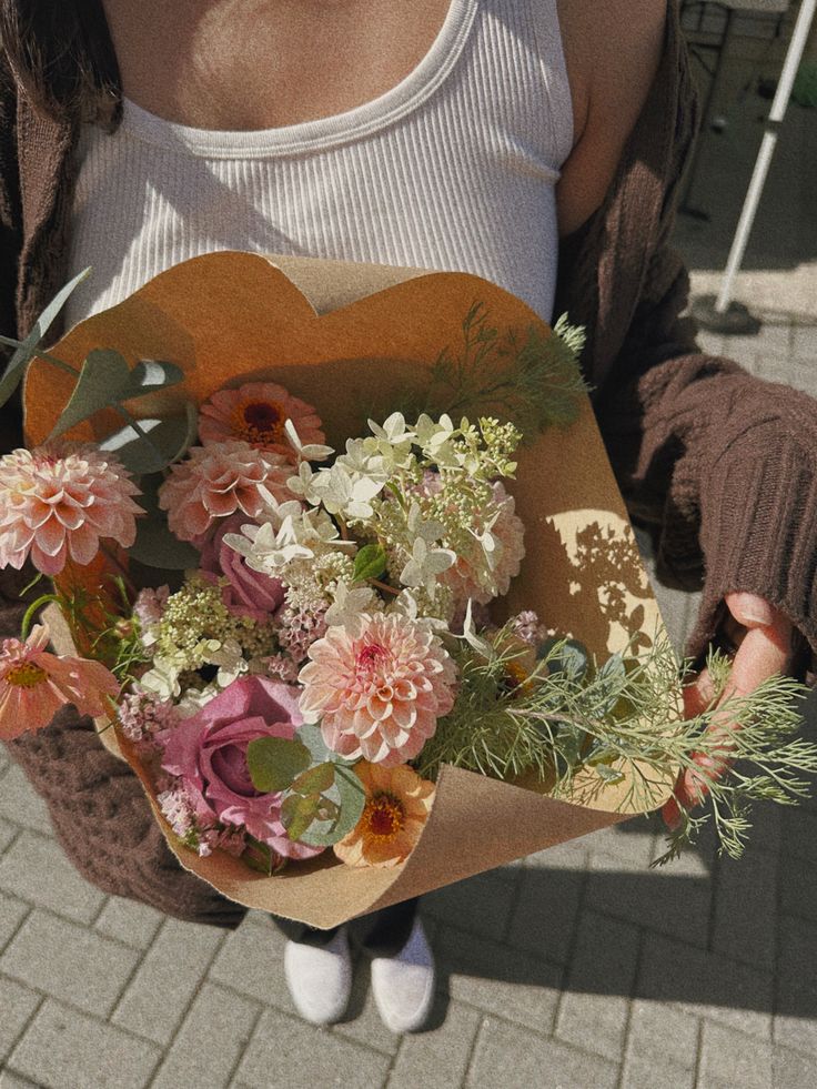 a woman holding a bouquet of flowers in her hands