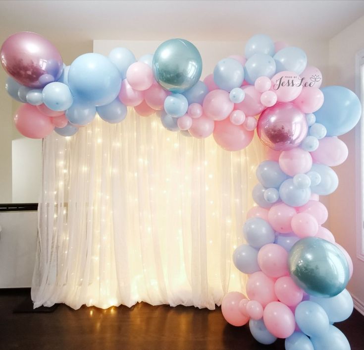 the balloon arch is decorated with pink, blue and white balloons