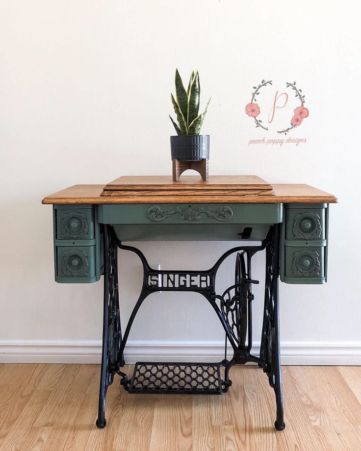 an old sewing machine with a plant on top